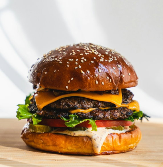 a hamburger sitting on top of a wooden cutting board